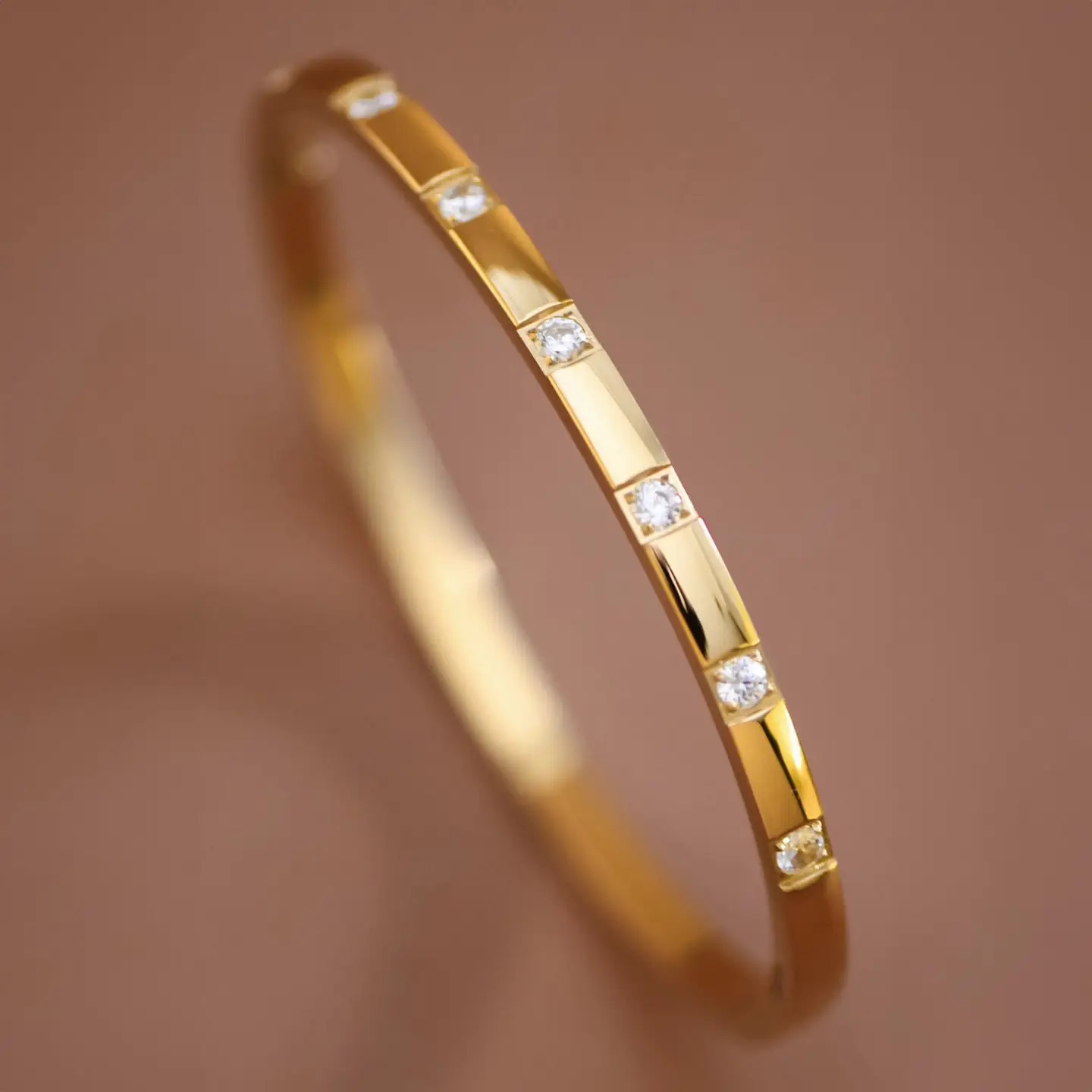 Polished gold bangle set with clear stones