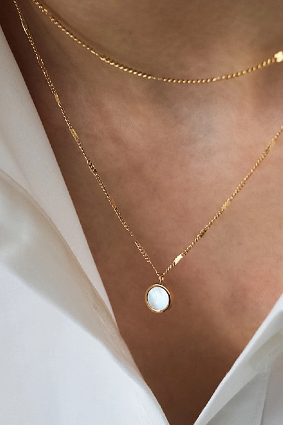 Gold chain necklace with a round mother-of-pearl pendant