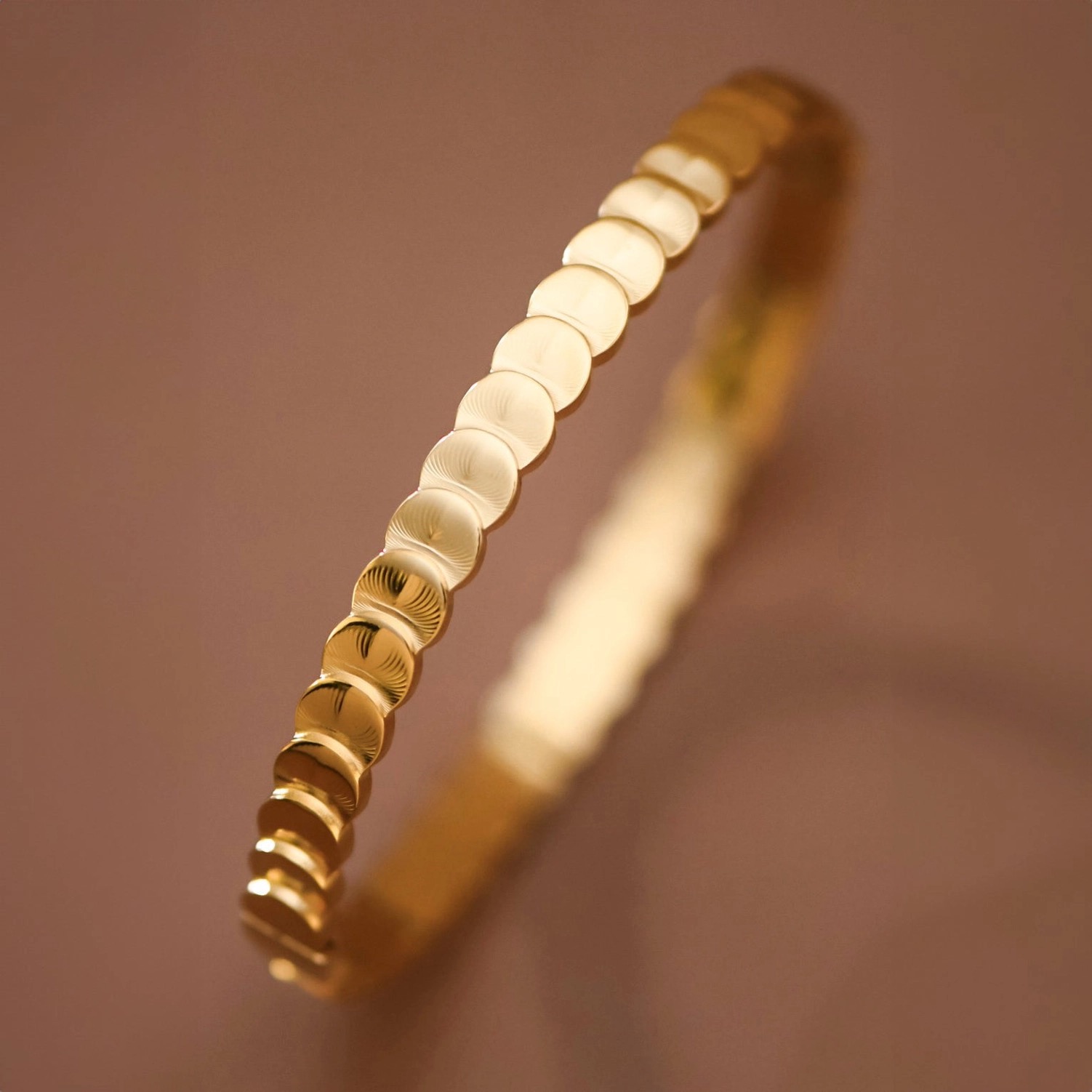 Textured gold bangle bracelet in warm light