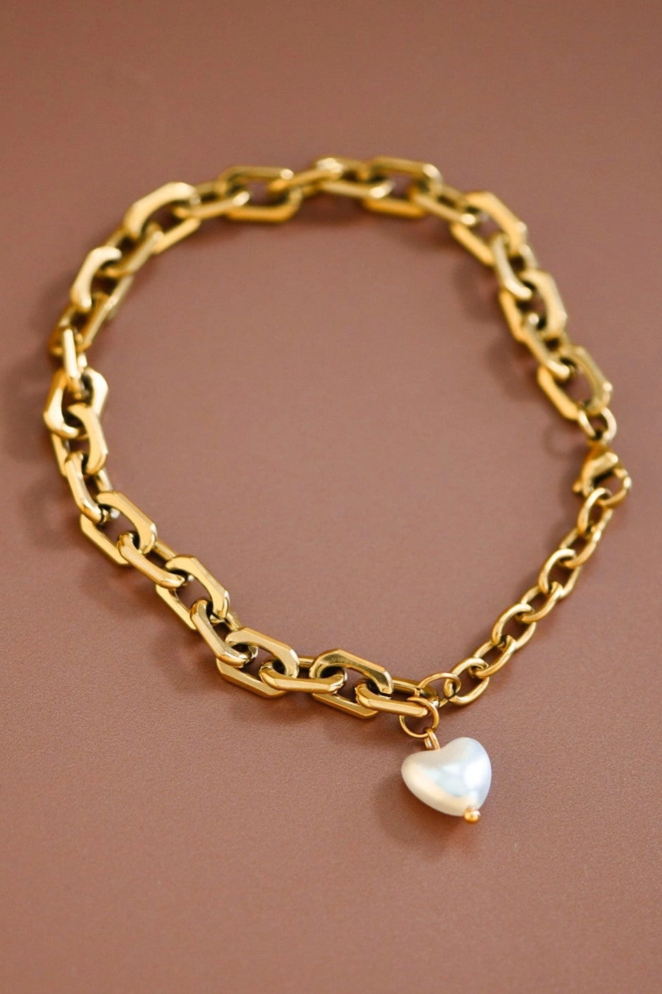 Bold gold chain bracelet with pearl heart charm